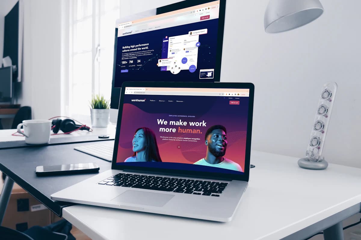 a desktop and a laptop are open to a web browser of the new Workhuman website