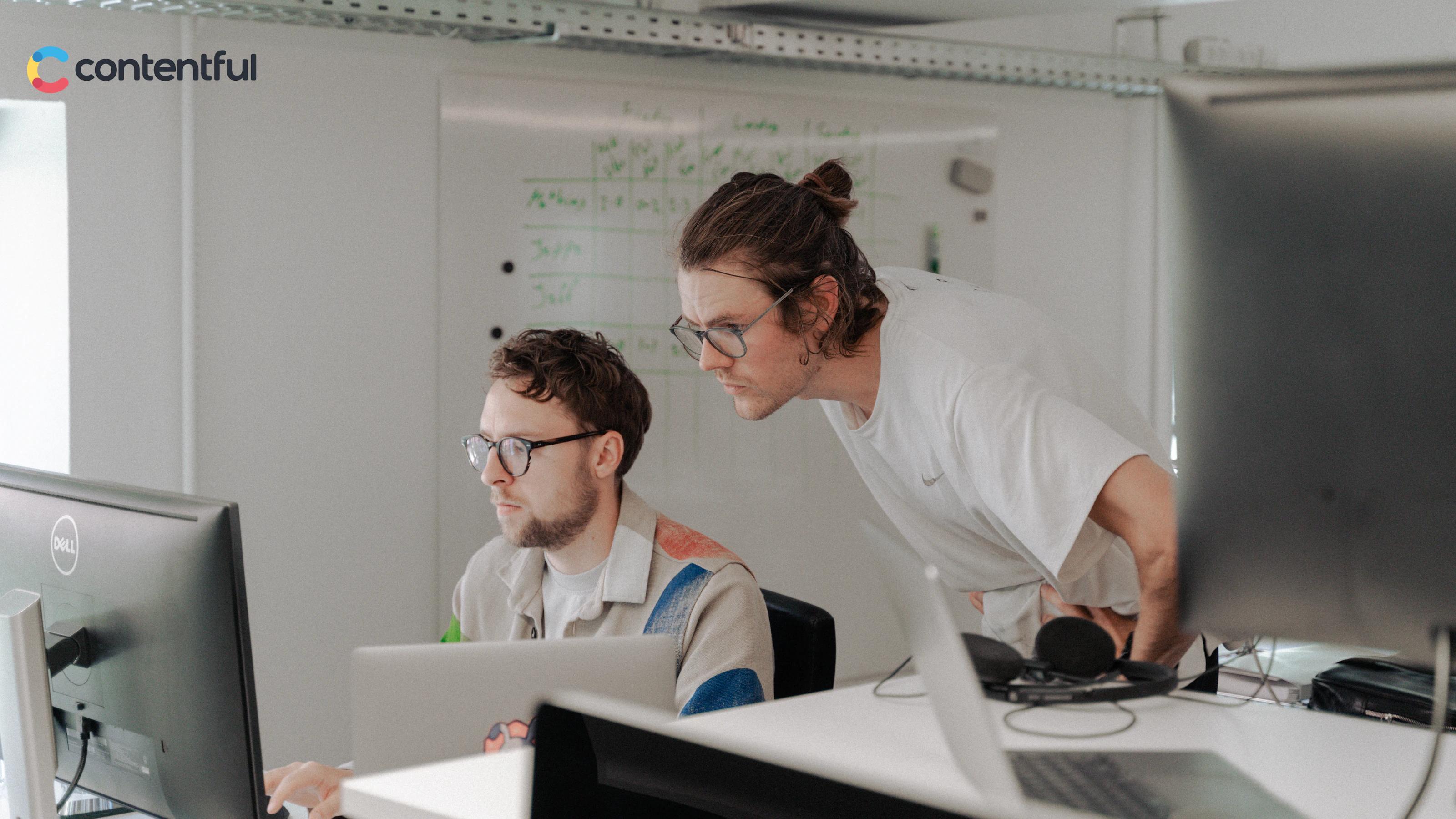 Two people looking at computer with Contentful logo