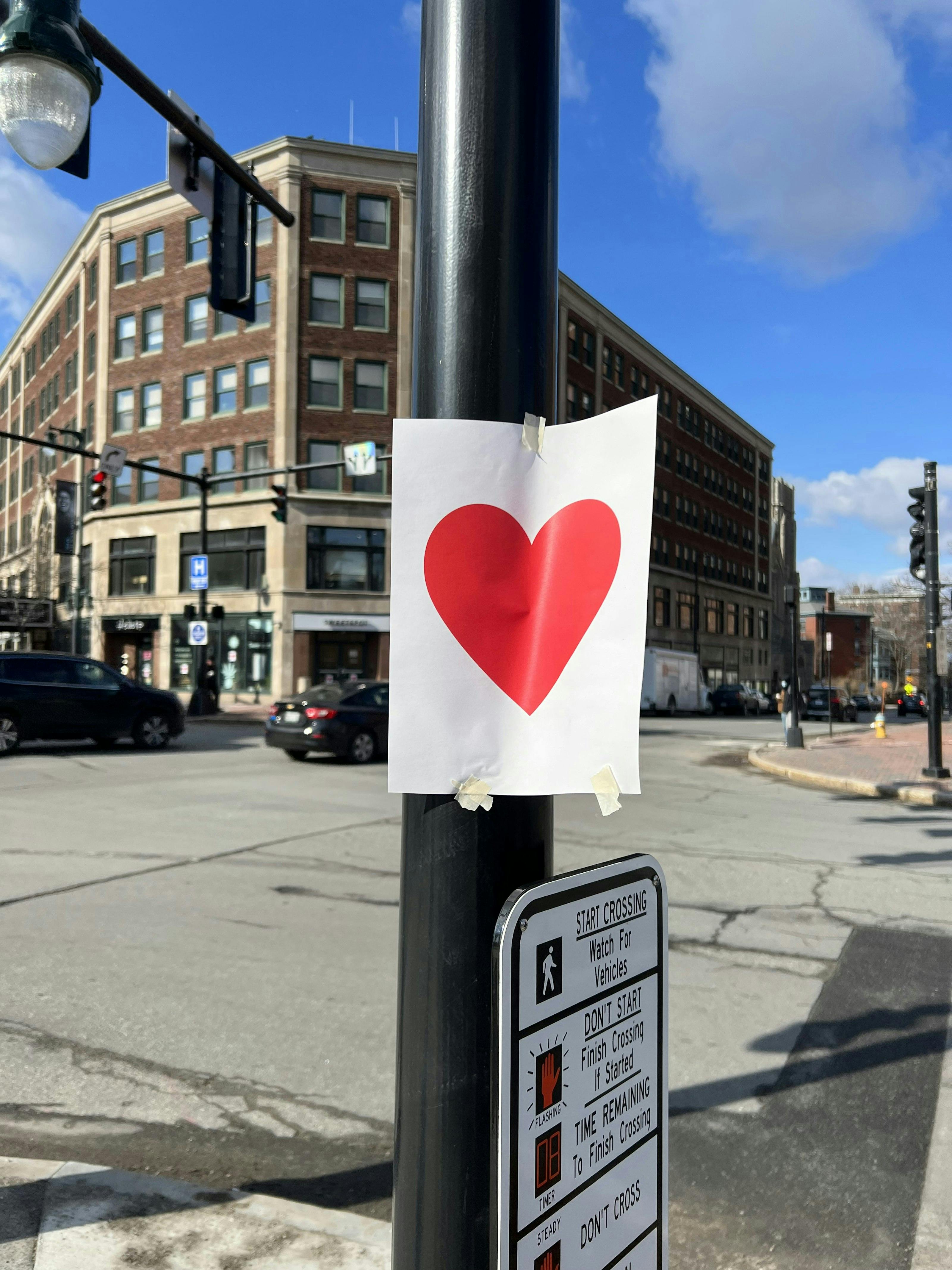 a red heart printed on a piece of paper is taped to a piece of a pole in Portland